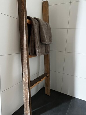 Ein Holzboden mit Handtüchern vor einer gefliesten Wand.