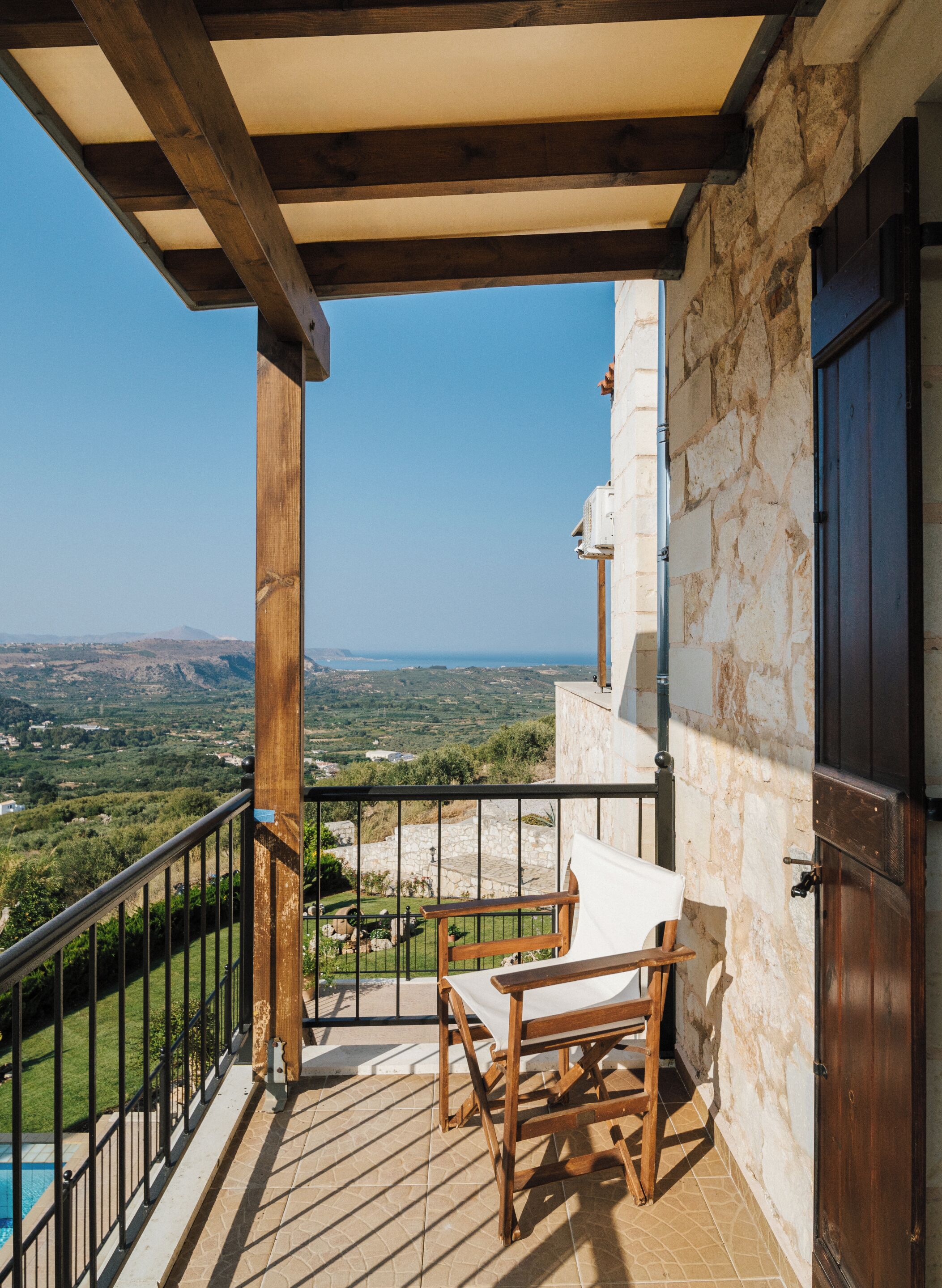 Un balcón con mesa y sillas de madera, con vistas a un paisaje pintoresco.