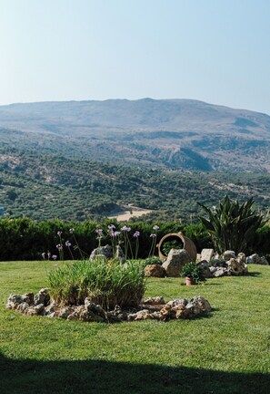 A landscaped garden with a view of a hilly landscape in the distance. - Villa Elia Provarma by Your Villa (Stilos)