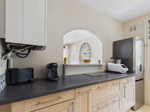 A kitchen with a black coffee maker, a toaster, and a modern refrigerator. - Seaside getaway for 2 with balcony (Les Sables-d´Olonne)