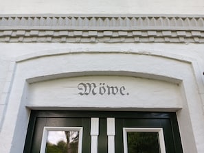 A building entrance with a white facade, a decorative cornice, and the word 'Möve.'