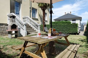 Ein Holztisch für ein Picknick mit Tischdecke, einer Flasche und einer Tasse.