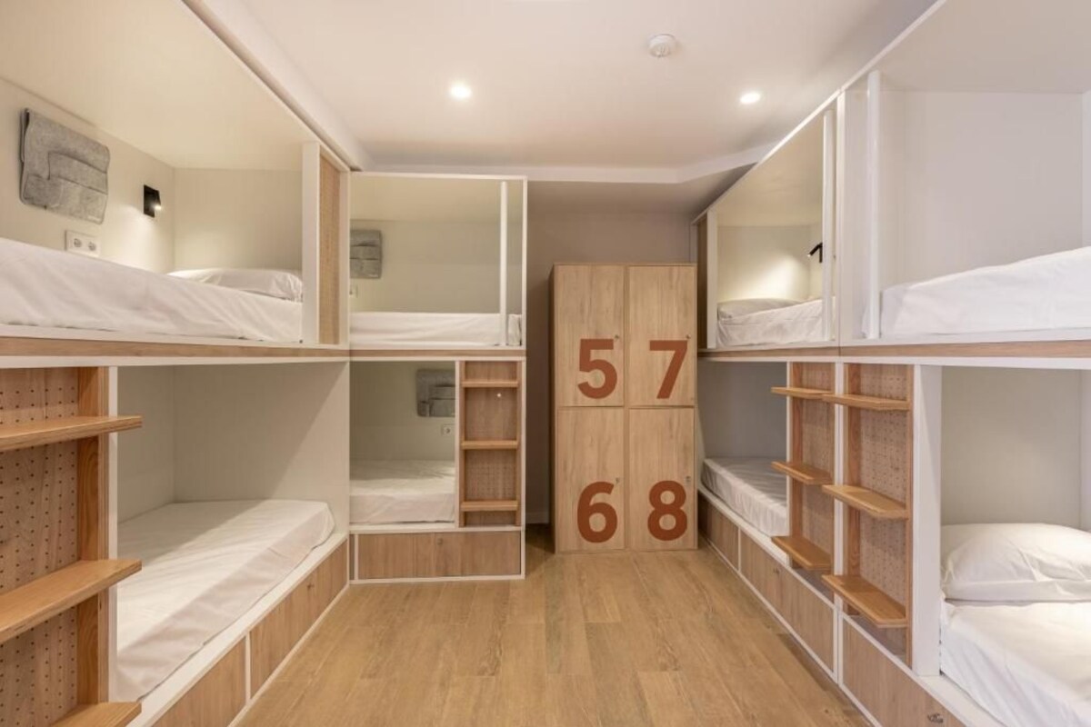 Une pièce avec des lits superposés, des étagères en bois et des blocs de construction.