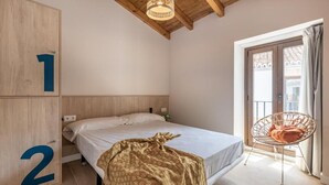 Une chambre à coucher avec un lit, une chaise et une porte portant des numéros.