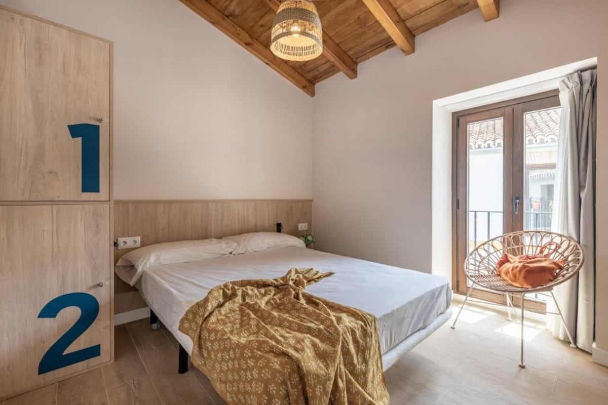 Une chambre à coucher avec un lit, une chaise et une porte portant des numéros.