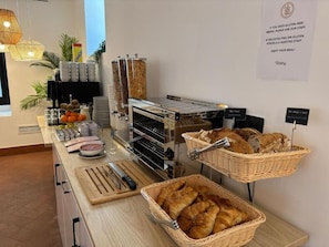 Un bufé de desayuno con distintos alimentos y utensilios.
