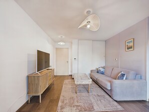 A modern living room with a sofa, a coffee table, a TV, and a cabinet. - Apartment for 2 adults/2 kids near Grande Plage (Les Sables-d´Olonne)