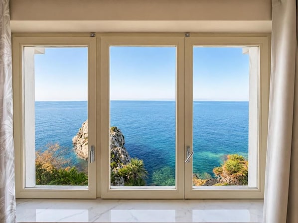 A room with a large window overlooking a coastal view. - Villa Crif (Bagheria)