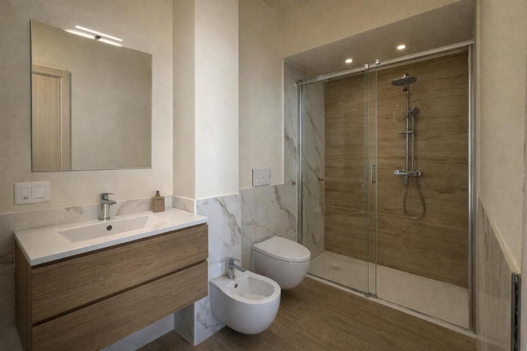 A modern bathroom with a large mirror, a marble sink, wooden cabinets, a bidet, and a glass-enclosed shower area.