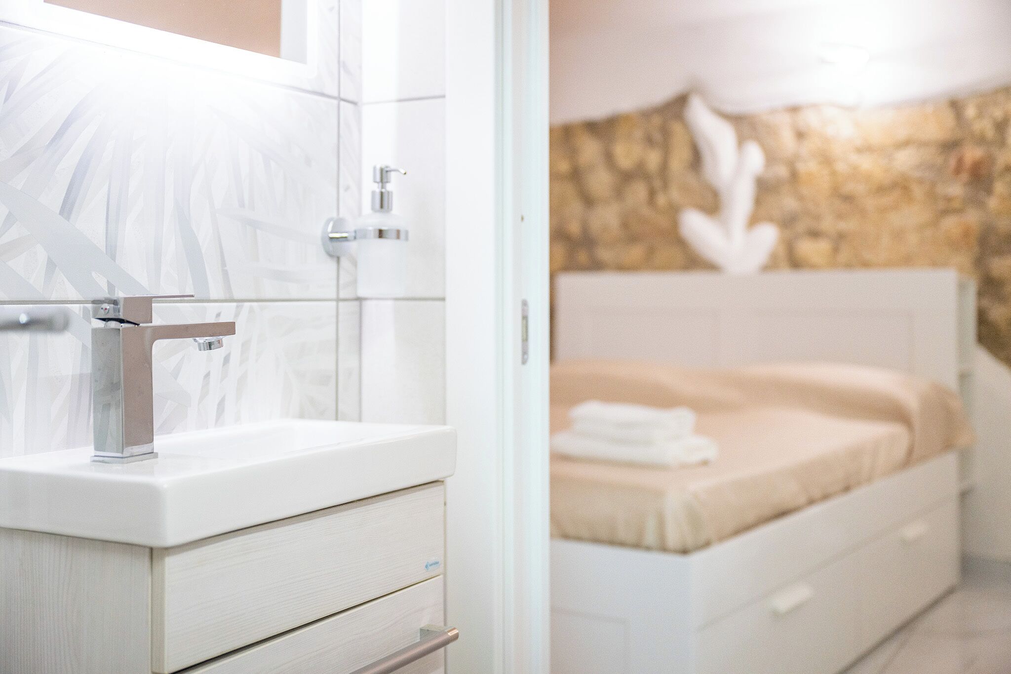 Ein Badezimmer mit einem weißen Waschbecken, einem Spiegel und einer Duschkabine.