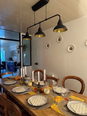 A dining table set with plates, glasses, and candles, with a kitchen visible in the background. - "Chez Laurette"—a vacation rental for 8 people between Beauval, Chambord, and Cheverny (Les Montils)