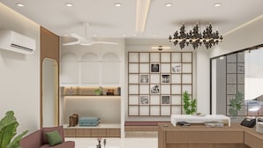 A modern hotel lobby with a reception desk, seating area, and a wall with framed pictures.