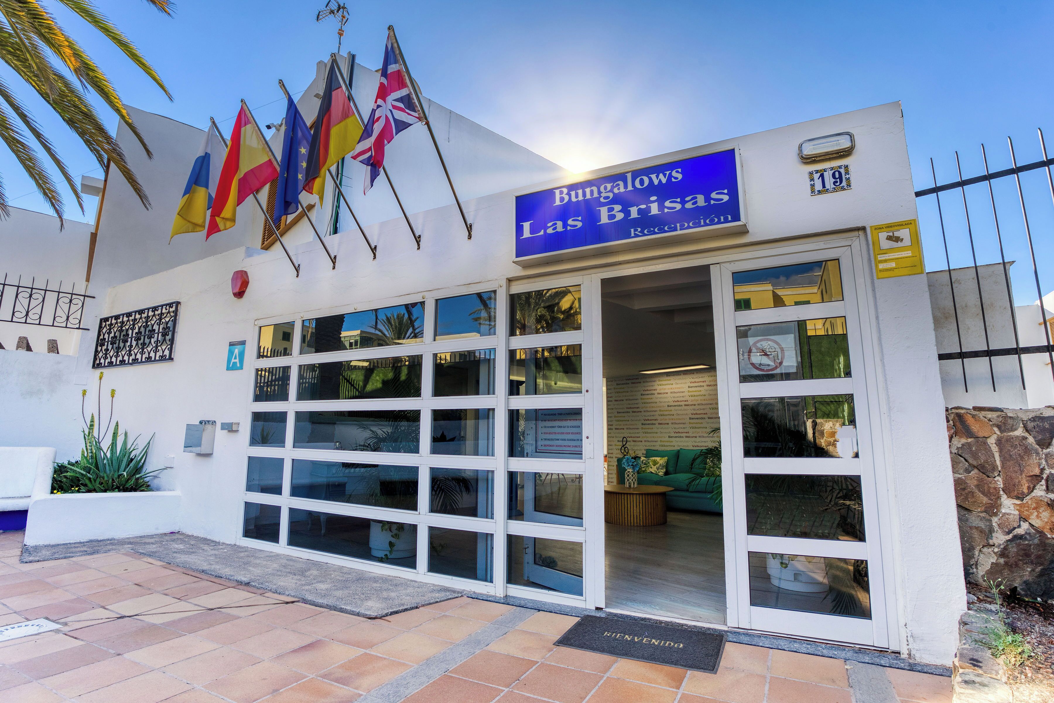 Un bâtiment sur lequel on peut lire l’inscription « Bungalows Las Brisas » et qui est orné de plusieurs drapeaux.