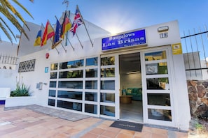 Un edificio con un letrero que dice 'Bungalows Las Brisas' y varias banderas.