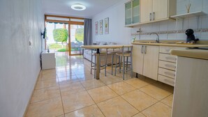 A kitchen with a dining area, a coffee machine, and a view of the outdoors. - Las Brisas (San Bartolomé de Tirajana)