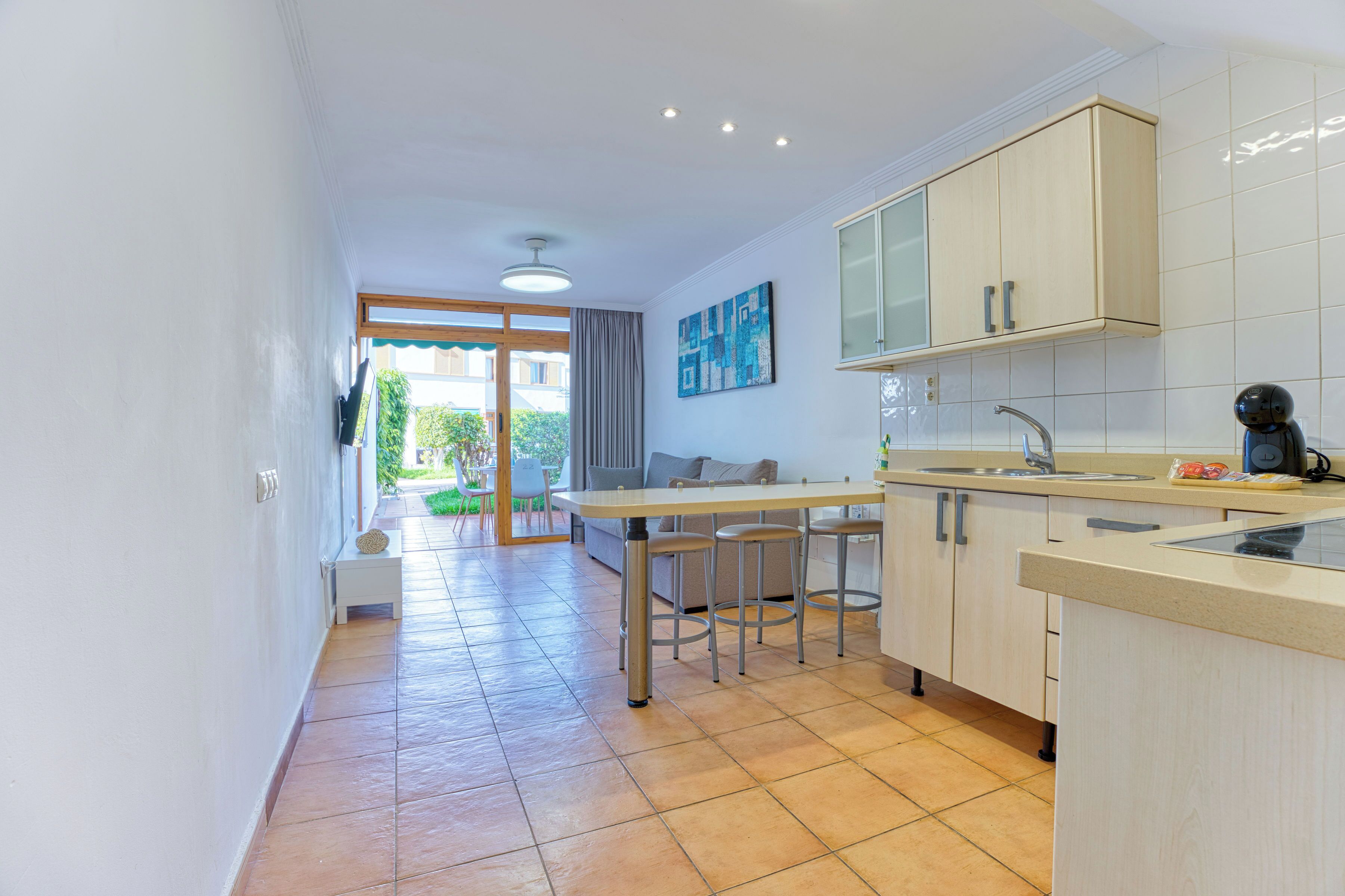 Una cocina moderna con comedor, vistas al exterior y una pequeña mesa con sillas.