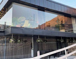 A modern building with large glass windows reflecting the surroundings.