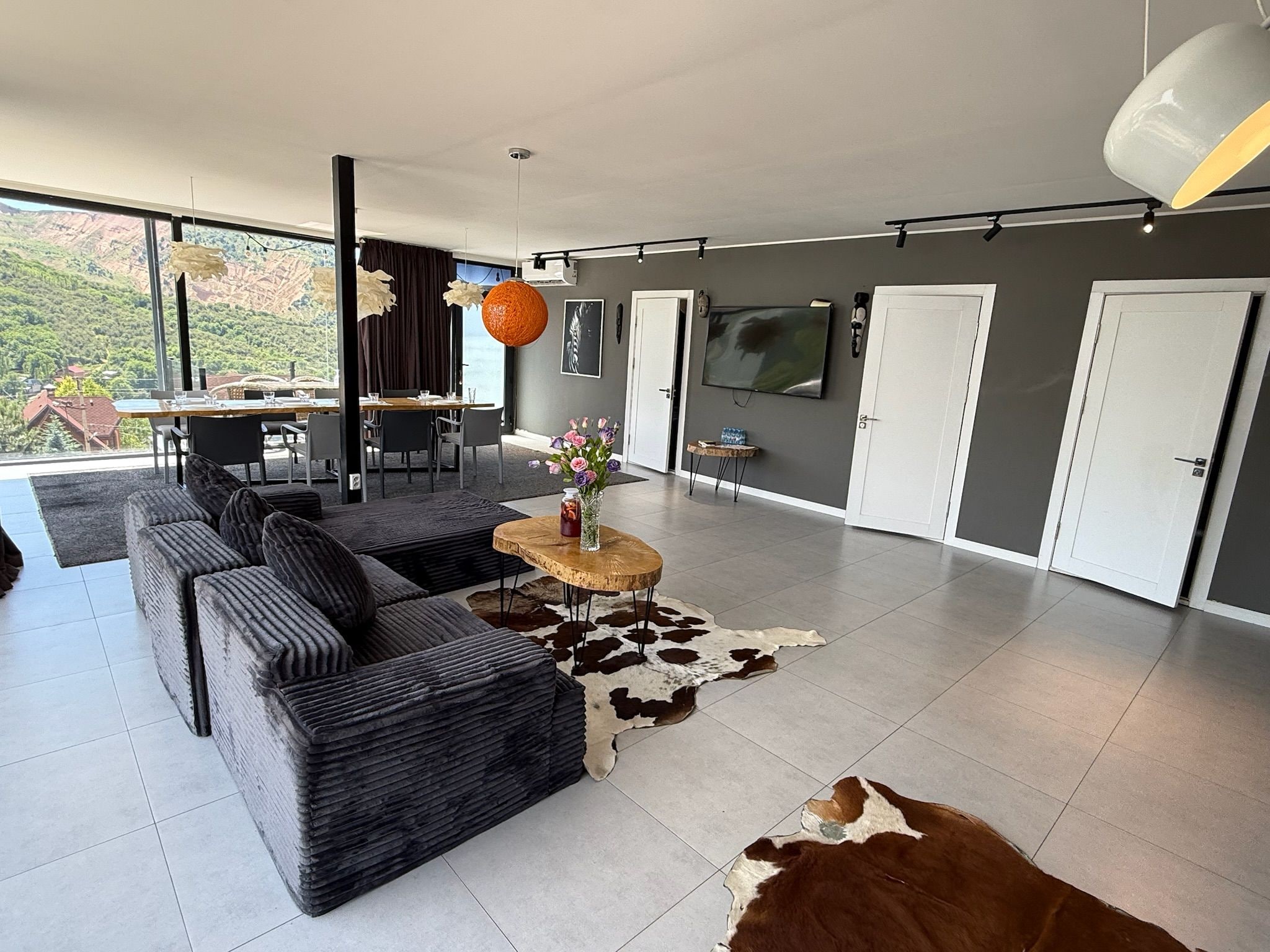 A modern living room with a sofa, a coffee table, and a television.