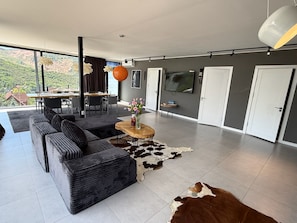 A modern living room with a sofa, a coffee table, and a television. - Balandda Chimgan (Chimgan)