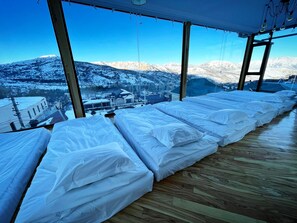 A room with large windows overlooking a snowy mountain landscape. - Balandda Chimgan (Chimgan)