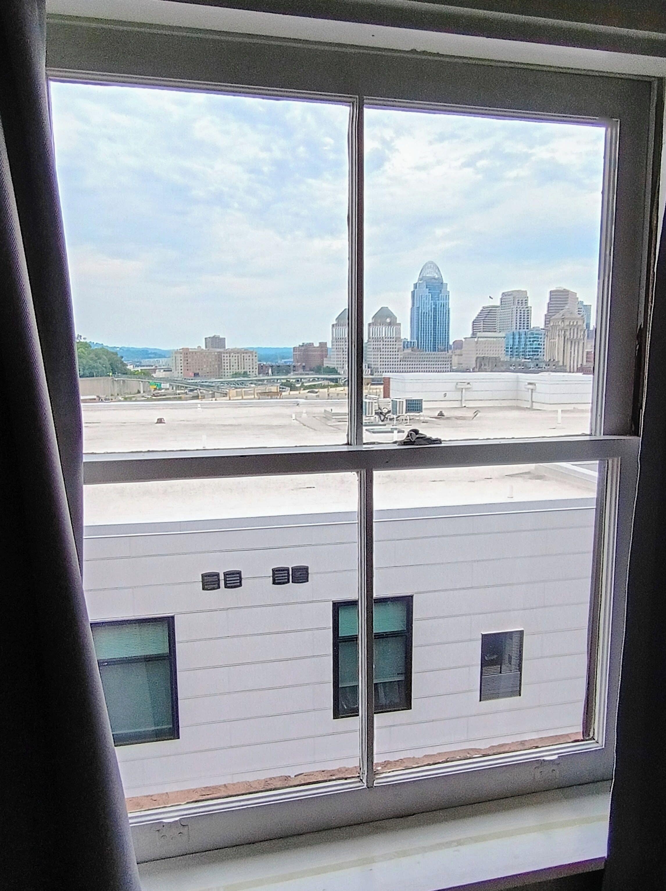 A view through a window of a building with a parking lot and a city skyline in the background.