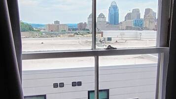 A view through a window of a building with a parking lot and a city skyline in the background.