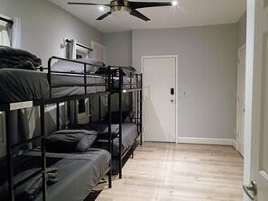 A bunk bed room with a ceiling fan, a door, and a light switch on the wall. - Edge of Downtown Cincinnati Two Floor Condo (Cincinnati)