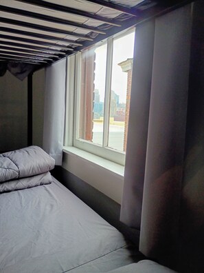 A room with a bed, a window, and a view of buildings outside. - Edge of Downtown Cincinnati Two Floor Condo (Cincinnati)