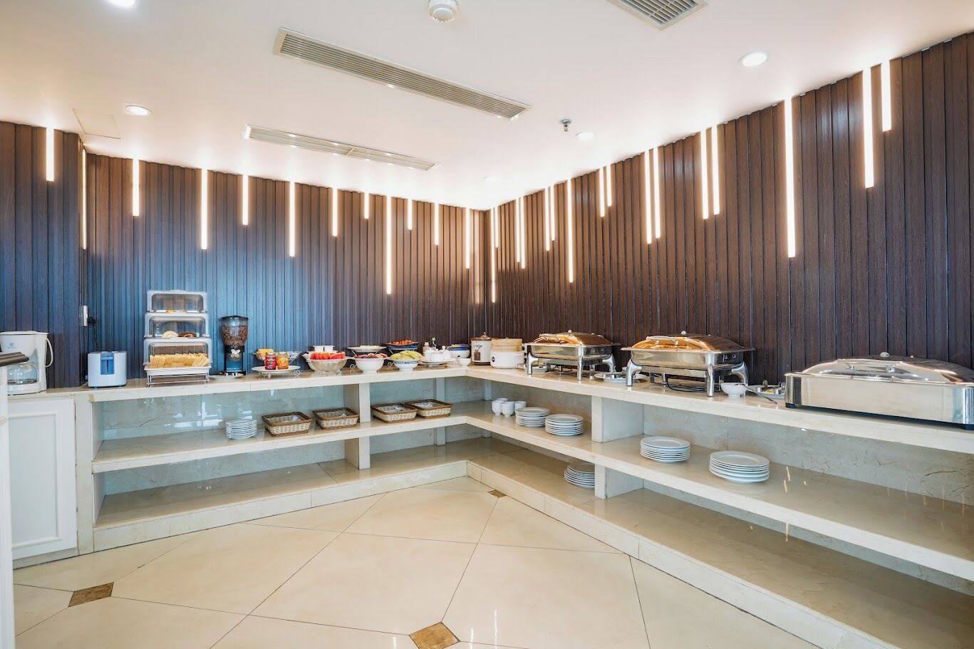 A buffet setup with various food items and a coffee station.