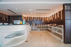 Un moderno comedor con una encimera blanca, diferentes alimentos y una pared con un diseño llamativo.