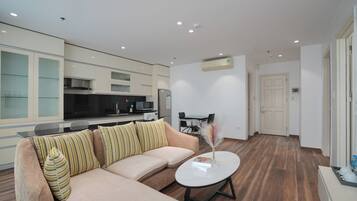 A modern living room with a sofa, a coffee table, and a dining area with chairs.