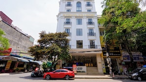 Um hotel com vários andares e uma placa grande com a inscrição 'GM INTERNATIONAL HOTEL & APARTMENT'.