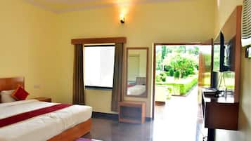 Une chambre d’hôtel avec un lit, un bureau, une chaise et une vue sur le jardin.