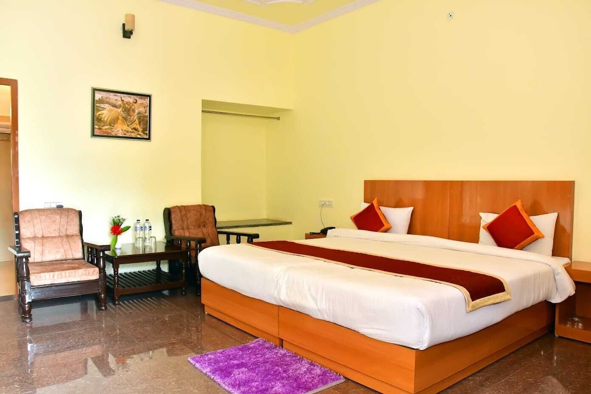 Une chambre d’hôtel avec un lit, un bureau, une chaise, un miroir et un tableau au mur.