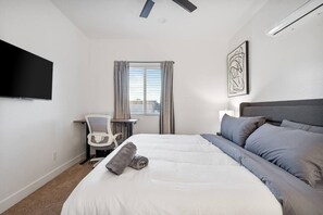 A hotel room with a bed, a desk, a chair, a TV, and a window with curtains. - Chic 1-Bedroom Retreat - Phoenix (Phoenix)