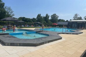 A swimming pool area with multiple pools and lounge chairs. - Holiday apartment with 3 bedrooms (Gramsbergen)