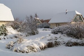 Un paysage enneigé avec des maisons et un ciel dégagé.