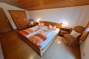 A bedroom with a wooden bed, two nightstands, a chair, and a wardrobe. - Lauchlehen - Fewo Göll (Bischofswiesen)
