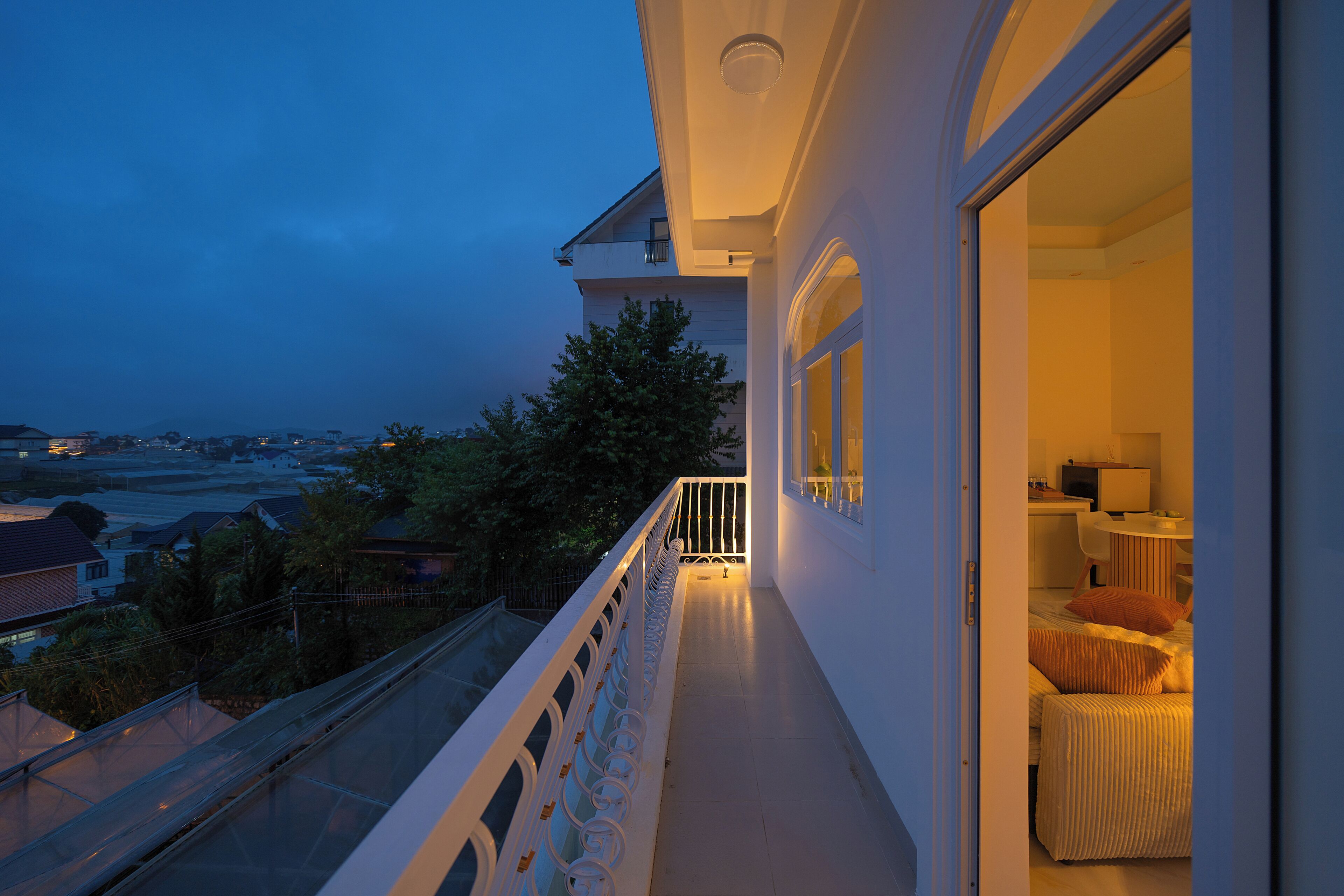 A balcony with a view of the cityscape at dusk.