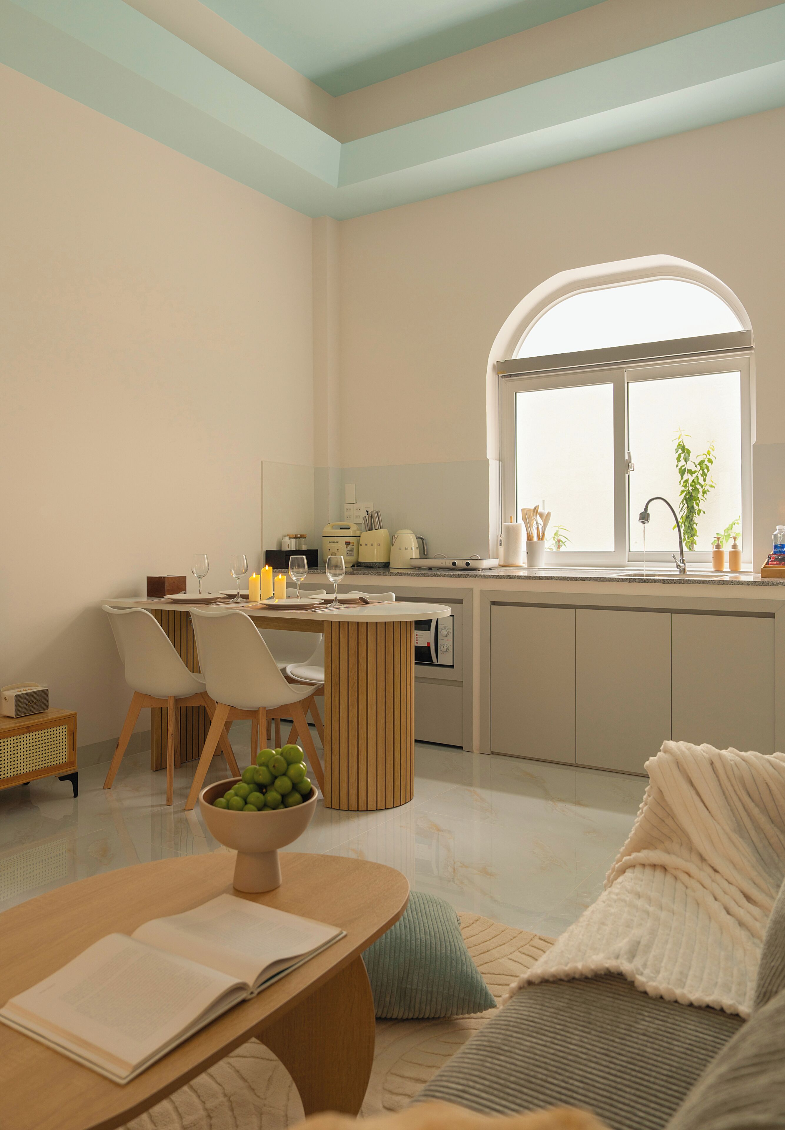 A modern kitchen with a dining area, a large window, and a cozy seating arrangement.