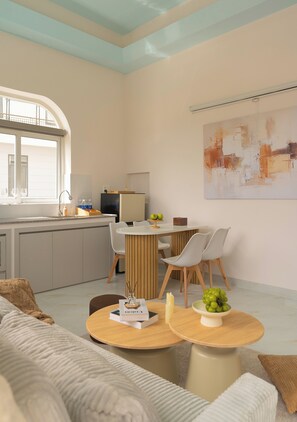 A modern living space with a kitchen, dining area, and a large window.