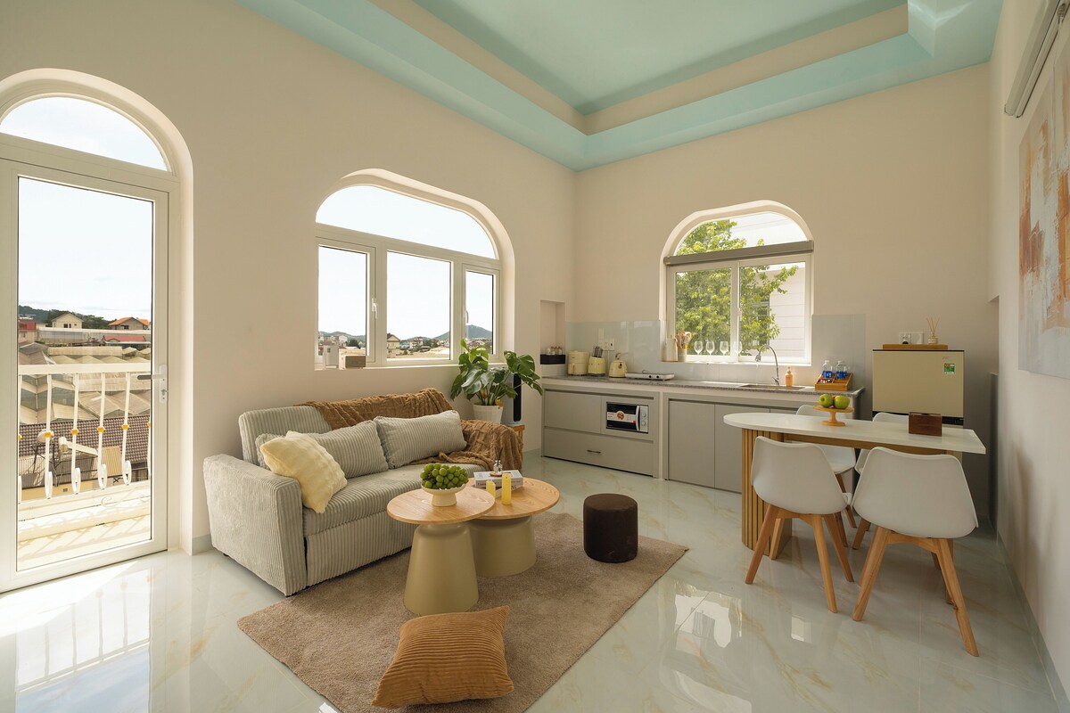 Een modern interieur met een bank, eettafel en keukenhoek.