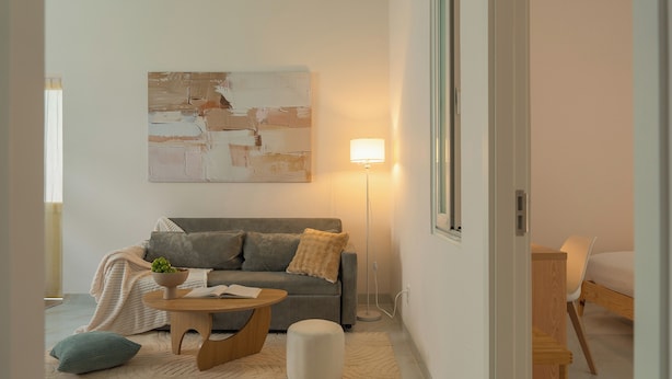 A modern living room with a sofa, a coffee table, and a lamp.