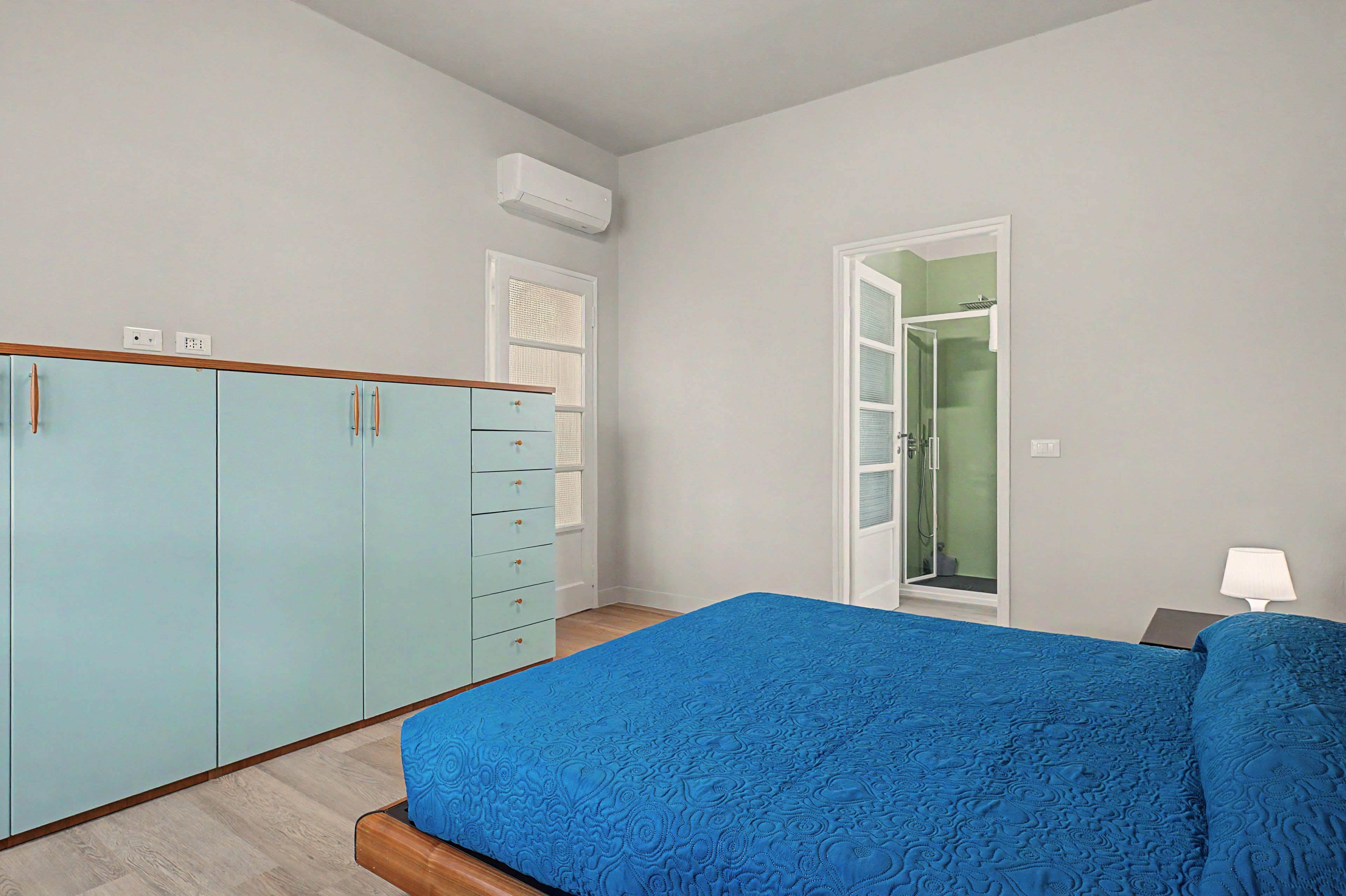 Une chambre à coucher comprenant un lit, une armoire et une porte donnant sur une salle de bain.