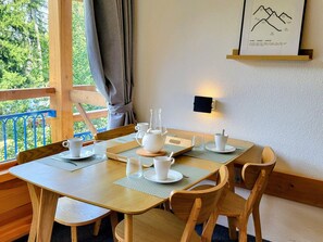 A dining area with a table set for four, including white cups, a pitcher, and a glass. - Studio cabin - ski-in/ski-out, balcony - 5 guests (Les Arcs 1800)