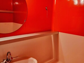 A bathroom with a white sink, a mirror, and a red wall. - Studio cabin - ski-in/ski-out, balcony - 5 guests (Les Arcs 1800)