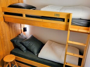 A bunk bed with a ladder, a small stool, and a wall-mounted light. - Studio cabin - ski-in/ski-out, balcony - 5 guests (Les Arcs 1800)
