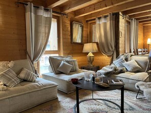 Ein gemütliches Zimmer mit zwei Sofas, einem kleinen Tisch und einer Lampe.