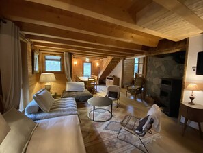 Un interior acogedor con sofá, sillas, una mesa de comedor y una chimenea.