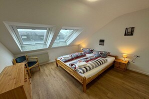 A bedroom with a wooden bed, two skylights, a desk, and a chair. - No. 16 - Winterhaldenweg 37 (Hinterzarten)